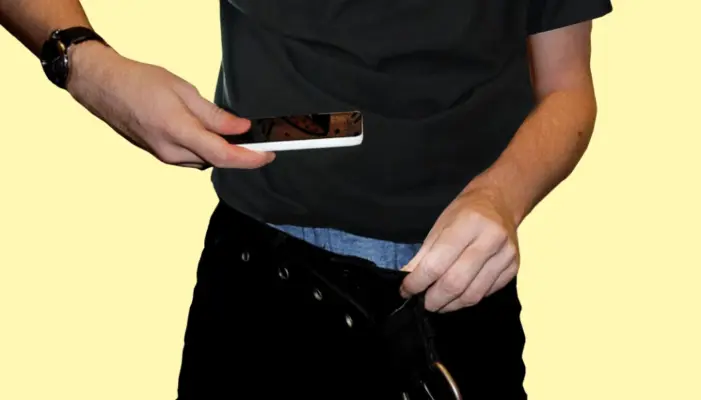 мужчина снимает дикпик оттянув штаны и направив туда телефон