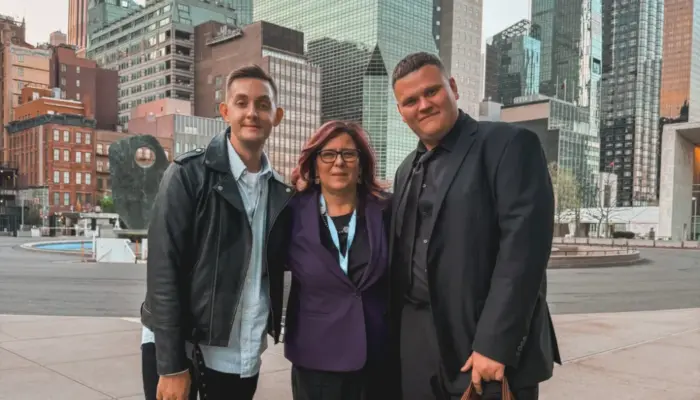 Фотография спецдокладчицы ООН по России Мариана Кацарова в окружении двух активистов из России на фоне высоток Нью-Йорка