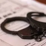 наручники лежат на папке с надписью "Уголовное дело"