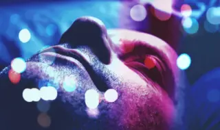 лицо спящего мужчины в сине-лиловом свете