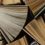 много частично раскрытых книг, не видно ни обложки, ни содержимого