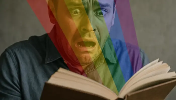 Радужный свет бьёт в глаза мужчине из открытой книги