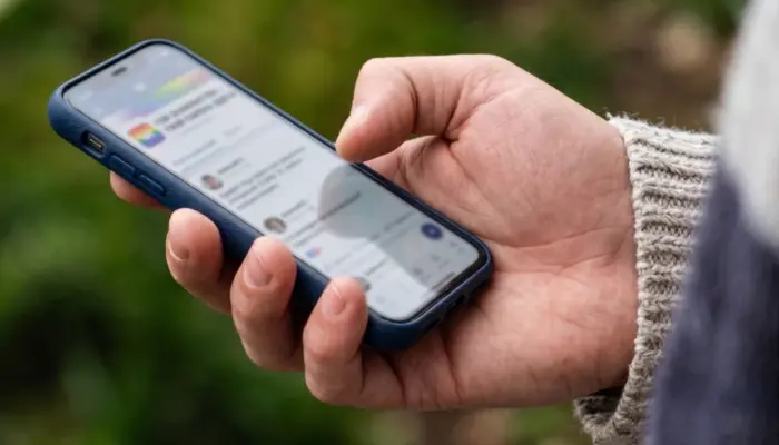 Телефон в руке мужчины, на экране знакомства ВКонтакте