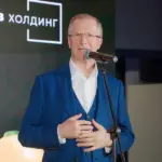 Виктор Шкулёв выступает на фоне логотипа своей формы «Шкулёв Холдинг»