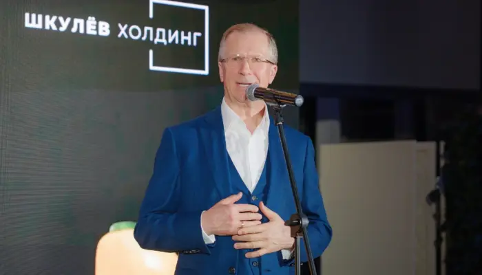 Виктор Шкулёв выступает на фоне логотипа своей формы «Шкулёв Холдинг»