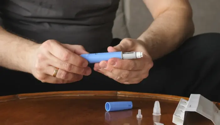 Мужчина держит в руках шприц-ручку для Оземпика