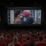 поцелуй персонажей Rohan and Josh в фильме The Parenting от HBO Max на экране в кинозале