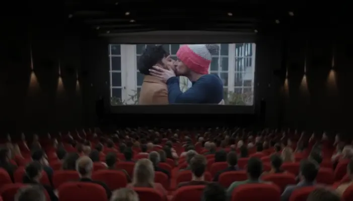 поцелуй персонажей Rohan and Josh в фильме The Parenting от HBO Max на экране в кинозале