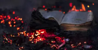 на иллюстрации книга тлеет на горячих углях