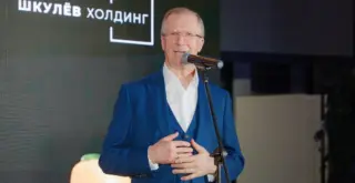 Виктор Шкулёв выступает на фоне логотипа своей формы «Шкулёв Холдинг»