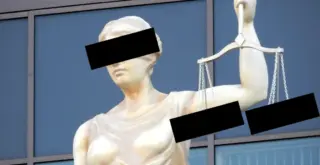 Статуя Фемиды, на фото чёрными прямоугольниками закрыты глаза и чаши весов в её руке