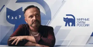 Игорь Кочетков на фоне символики партии Мирная Россия